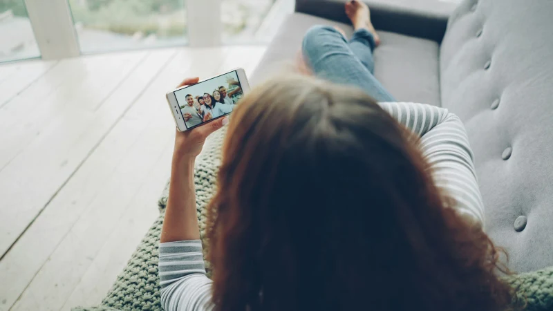 Family members connecting through a smartphone video call from home for virtual family therapy support