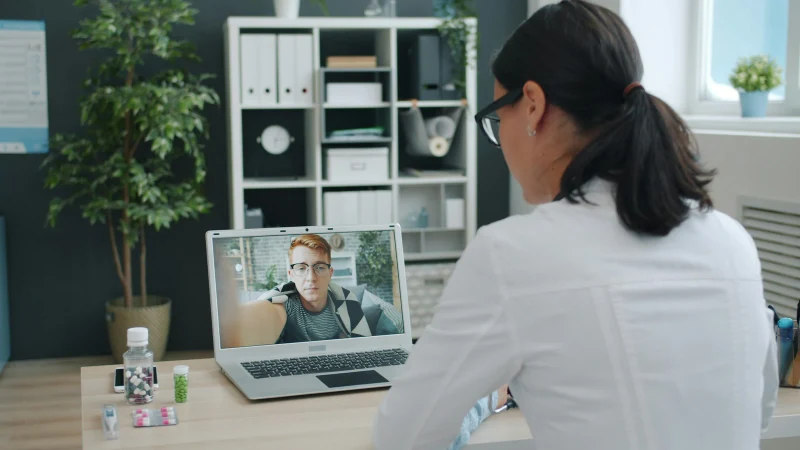 Healthcare provider on a laptop video call with a patient during a private telehealth session