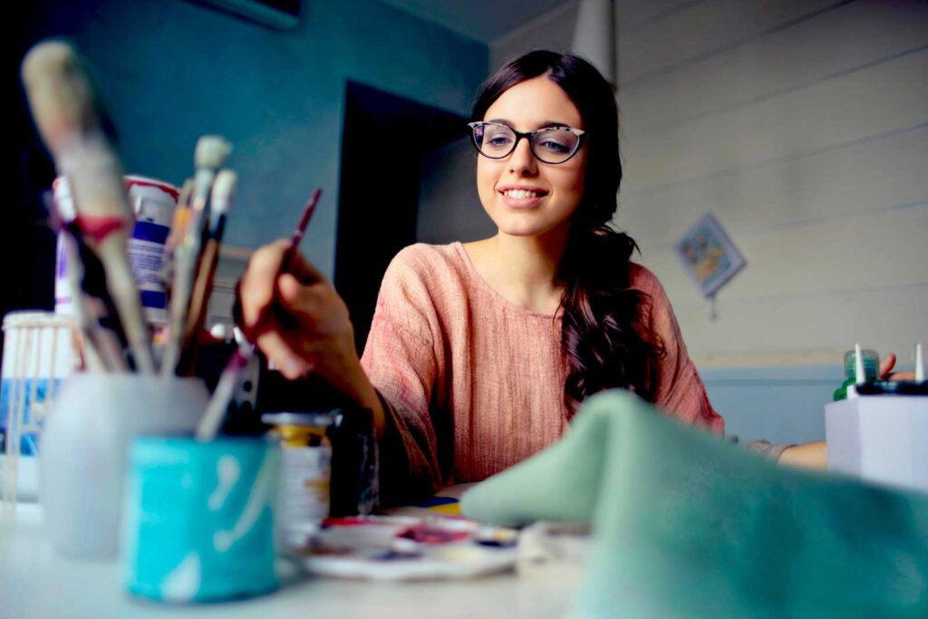 a girl paints during art therapy at alcohol treatment