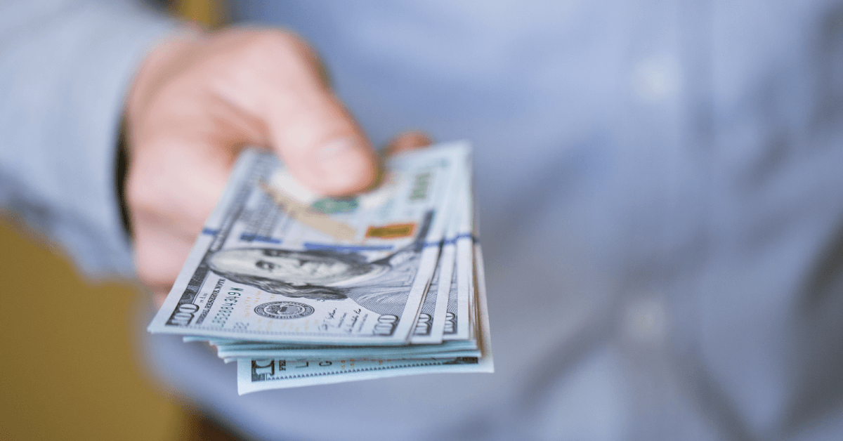 Man handing over pile of cash