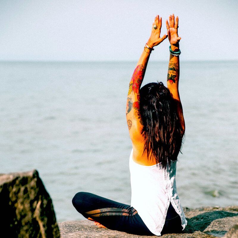 a woman in a Washington rehab does yoga by the ocean