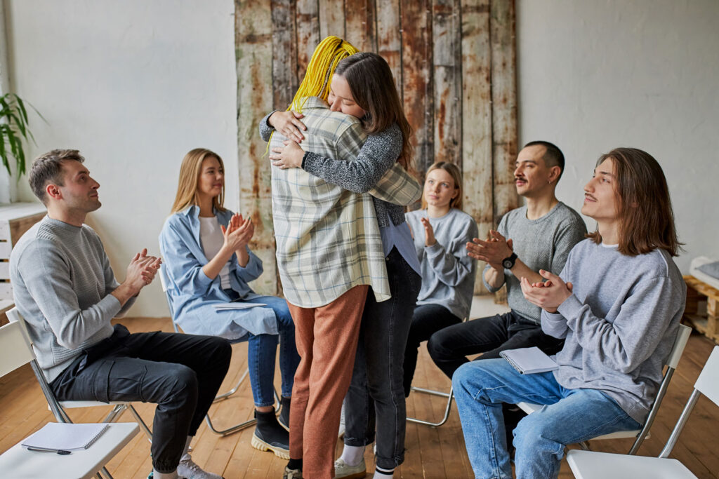 people hugging after discussing what therapy is most effective for addiction